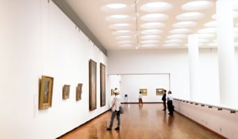 People in the gallery staring at classical paintings.