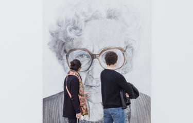 Visitors looking at a big painting of woman.